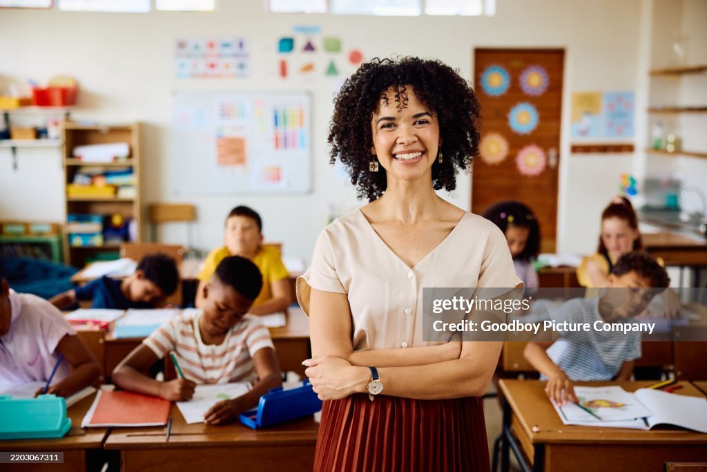 Young Female Teacher With Curly Hair In Classroom Smiling At ...
