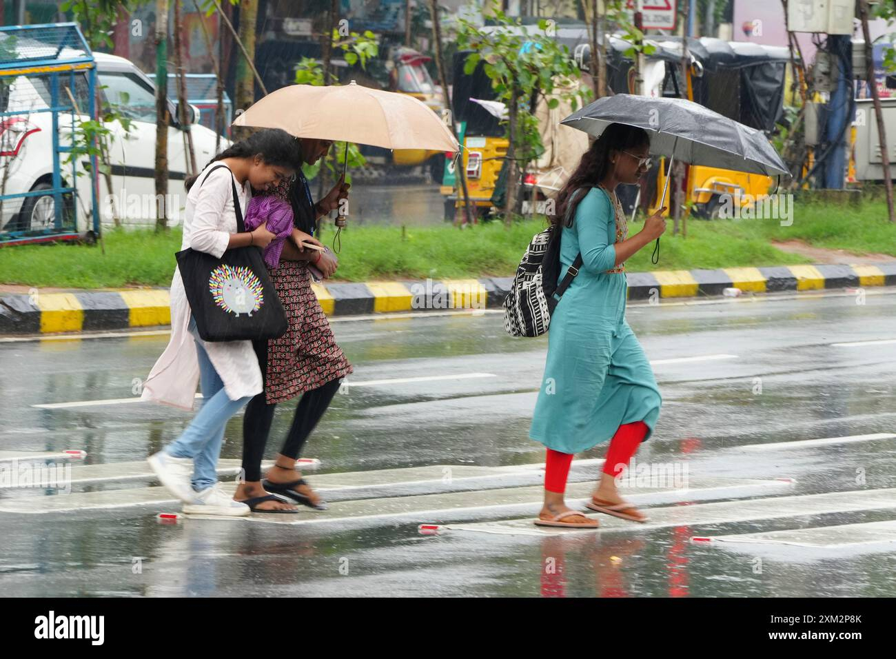 People walk with umbrellas in the rain in Hyderabad, India, Thursday, July 25, 2024. India receives its monsoon rains from June to September. (AP Photo/Mahesh Kumar A Stock Photo - Alamy